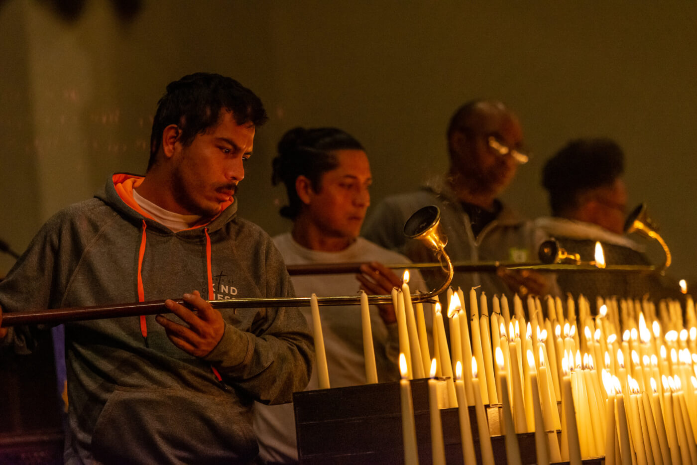 Img: People lighting rows of candles in a church